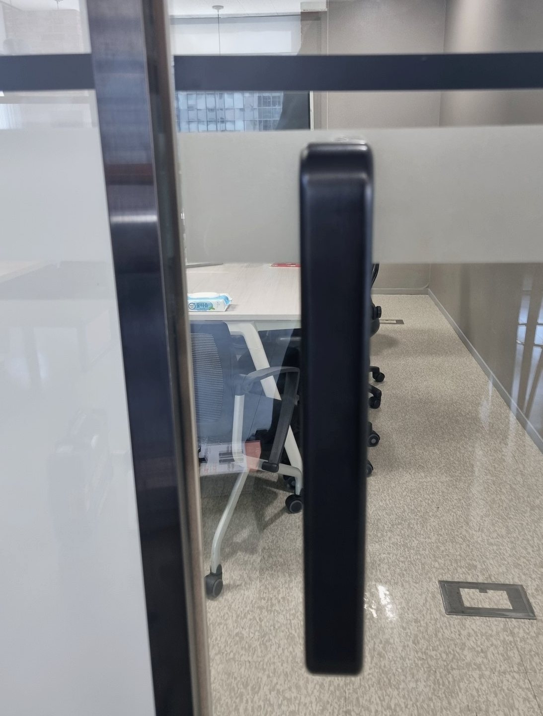 서대문구 홍제동 출장 — 사무실 유리문에 옆으로 붙은 검고 두툼한 도어락 본체와 유리 너머 회의 책상